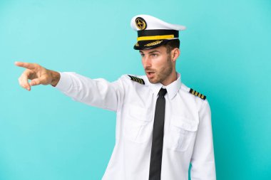 Kafkasyalı uçak pilotu mavi arka planda izole edildi.