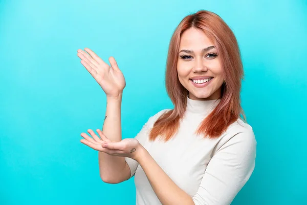 Jonge Russische Vrouw Geïsoleerd Blauwe Achtergrond Reikende Handen Aan Zijkant — Stockfoto