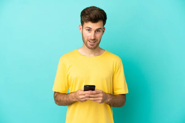 Joven Caucásico Guapo Hombre Aislado Azul Fondo Sorprendido Enviando Mensaje —  Fotos de Stock