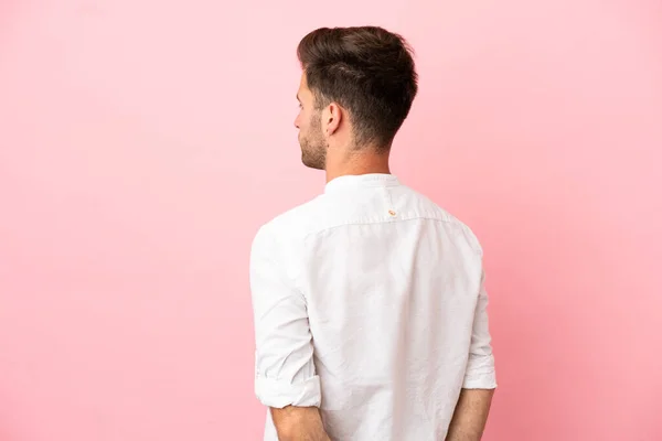 Jonge Blanke Knappe Man Geïsoleerd Roze Achtergrond Achterste Positie Terugkijkend — Stockfoto