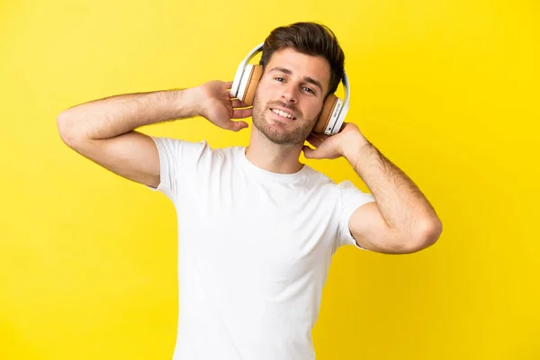 Νεαρός Καυκάσιος Όμορφος Άνδρας Απομονωμένος Κίτρινο Φόντο Ακούγοντας Μουσική — Φωτογραφία Αρχείου
