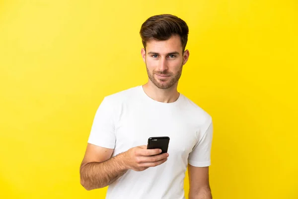 Jovem Caucasiano Bonito Homem Isolado Fundo Amarelo Usando Telefone Celular — Fotografia de Stock