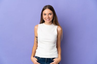 Genç Litvanyalı kadın, mor arka planda izole edilmiş gülüyor.