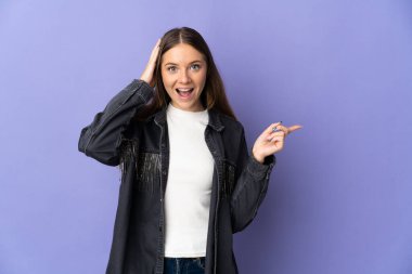 Mor arka planda izole edilmiş genç Litvanyalı kadın şaşırdı ve parmağını yana çevirdi.