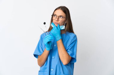 Litvanyalı kadın diş hekimi, izole edilmiş arka plan üzerinde araçlar tutuyor.