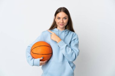 Basketbol oynayan Litvanyalı genç bir kadın beyaz arka planda izole edilmiş bir şekilde bir ürünü sunmak için kenarı işaret ediyor.