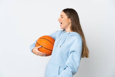 Basketbol oynayan Litvanyalı genç bir kadın beyaz arka planda izole edilmiş ve yan yana gülüyor.