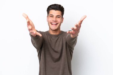 Beyaz fırında soyutlanmış yakışıklı beyaz bir adam sunar ve davet eder.