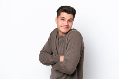 Beyaz fırında izole edilmiş yakışıklı beyaz bir adam omuzlarını kaldırırken şüpheyle hareket ediyor.