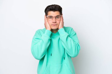 Beyaz fırında izole edilmiş yakışıklı beyaz adam hayal kırıklığına uğramış ve kulaklarını kapatmış.