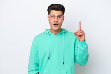 Beyaz bakkalda izole edilmiş yakışıklı beyaz adam çözümü bulmak için parmağını kaldırıyor.