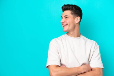 Genç, yakışıklı, beyaz bir adam mavi fırında tek başına mutlu ve gülümsüyor.