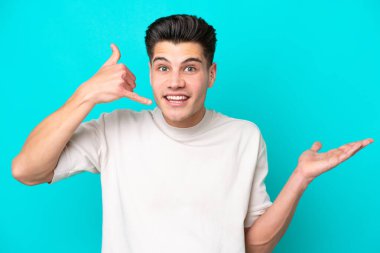 Genç, yakışıklı, beyaz bir adam, mavi bir bakkalda izole edilmiş, telefon hareketleriyle kuşkulanıyor.