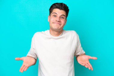 Genç, yakışıklı, beyaz bir adam mavi fırında tek başına mutlu ve gülümsüyor.