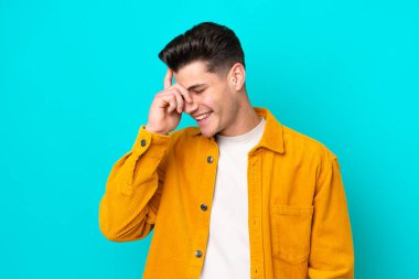 Genç, yakışıklı, beyaz bir adam mavi fırında yapayalnız gülüyor.