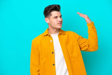 Genç, yakışıklı, beyaz bir adam mavi fırında izole edilmiş, yorgun ve hasta bir yüz ifadesi var.