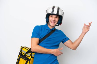 Beyaz arka planda izole edilmiş termal sırt çantalı beyaz bir adam gitar hareketi yapıyor.