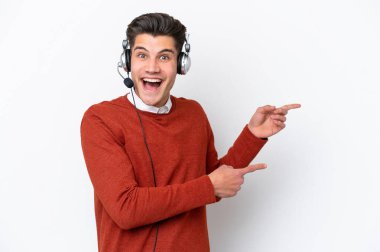 Tele pazarlamacı, beyaz arka planda izole edilmiş bir kulaklıkla çalışan beyaz bir adam şaşırmış ve işaret ediyor.