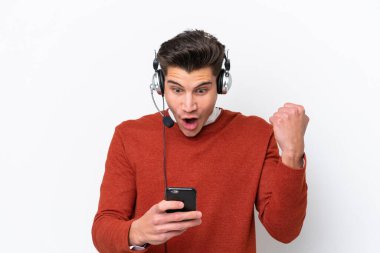 Beyaz arka planda izole edilmiş bir kulaklıkla çalışan beyaz pazarlamacı bir adam şaşırdı ve bir mesaj gönderiyor.