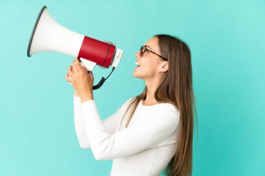 Soyutlanmış mavi arka planda genç bir kadın megafondan bir şey duyurmak için bağırıyor.