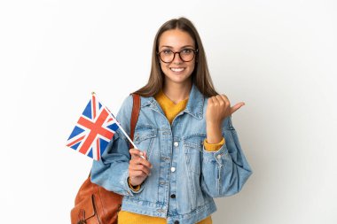 Birleşik Krallık bayrağını tek başına beyaz arka planda tutan genç İspanyol kadın bir ürünü sunmak için kenarı işaret ediyor.