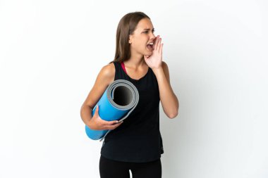 Spor kadını yoga derslerine giderken, arka planda izole edilmiş beyaz bir paspas tutuyor ve ağzı açık bağırıyor.