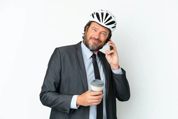 白い背景に隔離された自転車のヘルメットを持つビジネスマンは コーヒーを取り上げ モバイルを保持 — ストック写真