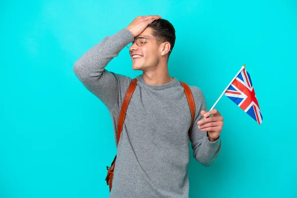 青色の背景に隔離された英国の旗を持っている若い白人男性は何かを実現し 解決策を意図しています — ストック写真