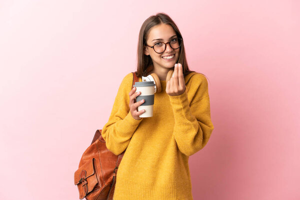 Young student woman over isolated pink background making money gesture