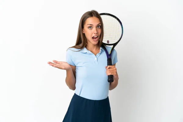 ショックを受けた顔の表情で隔離された白い壁の上にテニスをする女性 — ストック写真