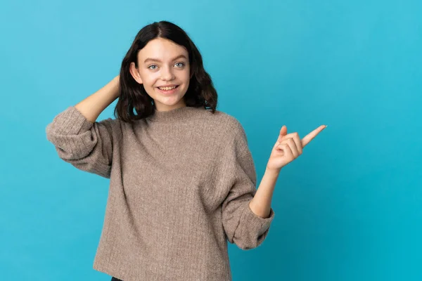 ティーンウクライナ人の女の子隔離上の青の背景驚きと指摘指へ側 — ストック写真