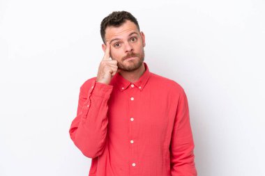 Genç Brezilyalı bir adam beyaz arka planda izole edilmiş bir fikir düşünüyor.