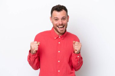 Genç Brezilyalı adam beyaz arka planda tek başına zaferi kutluyor.