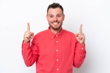 Beyaz arka planda izole edilmiş genç Brezilyalı adam harika bir fikre işaret ediyor.