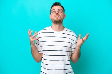 Mavi arka planda izole edilmiş genç Brezilyalı adam bunalıma girdi.