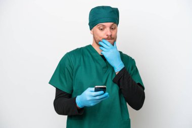 Cerrah Brezilyalı yeşil üniformalı adam beyaz arka planda izole edilmiş düşünüyor ve bir mesaj gönderiyor.