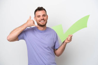 Beyaz arka planda izole edilmiş genç Brezilyalı bir adam elinde bir çek ikonu ve telefon hareketi yapıyor.