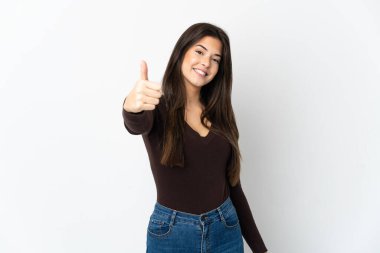 Genç Brezilyalı kız beyaz arka planda izole edildi. Başparmakları havada çünkü iyi bir şey oldu.