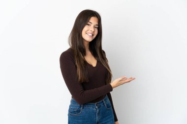 Genç Brezilyalı kız beyaz arka planda soyutlanmış bir fikir sunuyor ve gülümsüyor.