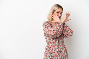 Beyaz arka planda izole edilmiş genç beyaz kadın ellerini öne uzatıyor.