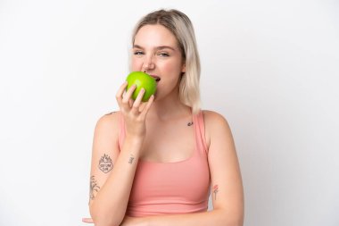Beyaz arka planda izole edilmiş beyaz bir kadın elma yiyor.