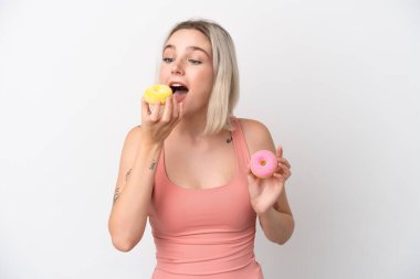 Beyaz arka planda izole edilmiş beyaz bir kadın donut yiyor.