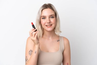 Beyaz arka planda kırmızı ruj tutan beyaz tenli genç bir kadın.