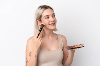 Beyaz arka planda makyajlı ve mutlu beyaz bir kadın.