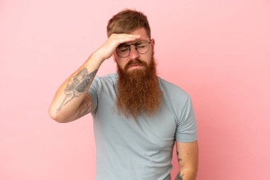 Kırmızımsı beyaz adam pembe arka planda baş ağrısı ile izole edildi.