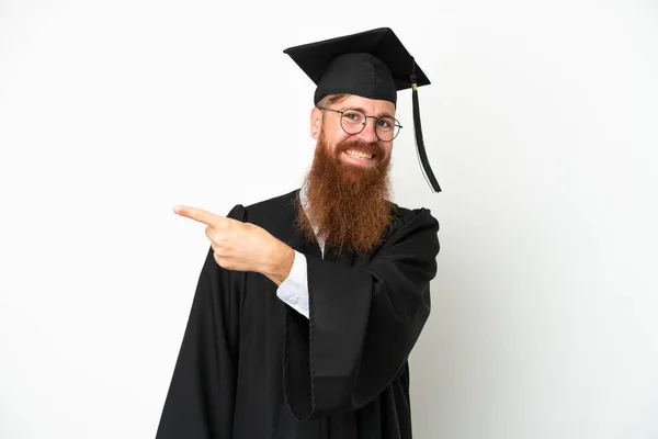 Jovem Universitário Graduado Homem Avermelhado Isolado Fundo Branco Apontando Para — Fotografia de Stock