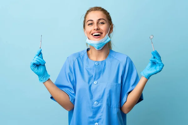 Junge Zahnärztin Hält Werkzeug Über Isolierten Blauen Hintergrund — Stockfoto