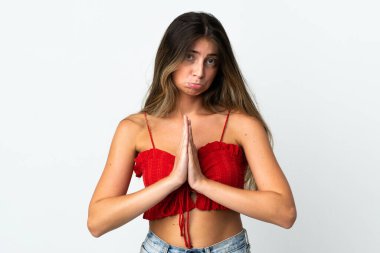 Beyaz arka planda izole edilmiş genç beyaz kadın avuç içlerini bir arada tutuyor. İnsan bir şey ister.