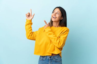 Mavi arka planda izole edilmiş beyaz bir kız işaret parmağıyla işaret etmek harika bir fikir.