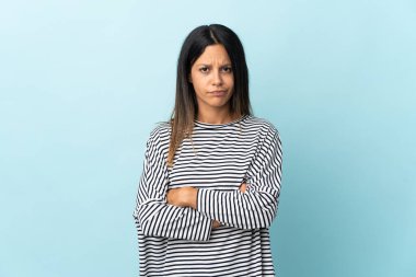 Mavi arka planda izole edilmiş beyaz kız üzgün hissediyor.